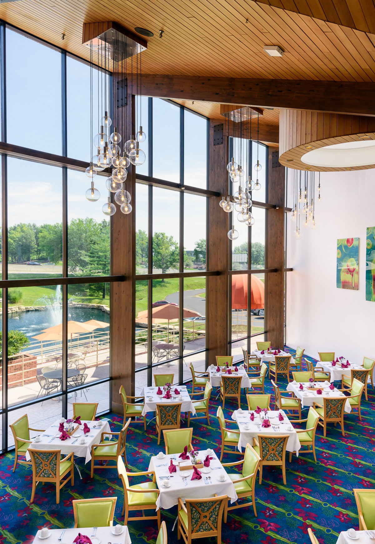 A modern restaurant interior with large windows and elegantly set tables.