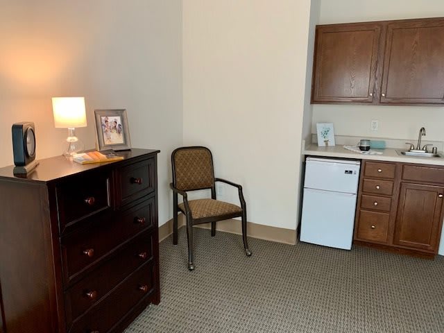 A cozy room with furniture and a kitchenette area.