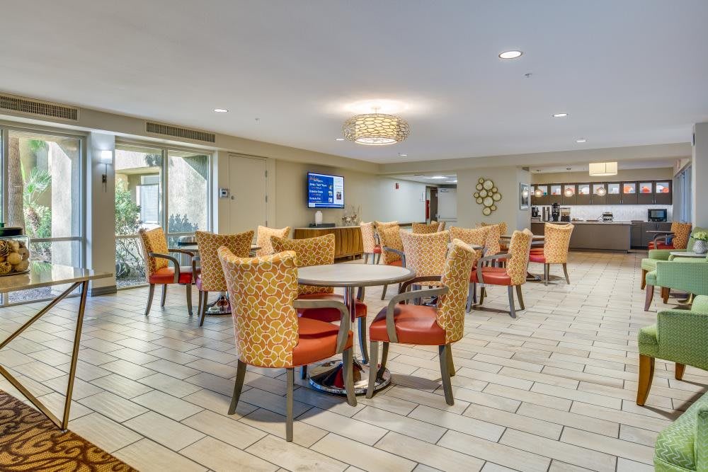 A modern dining area with neatly arranged tables and chairs, featuring contemporary decor.