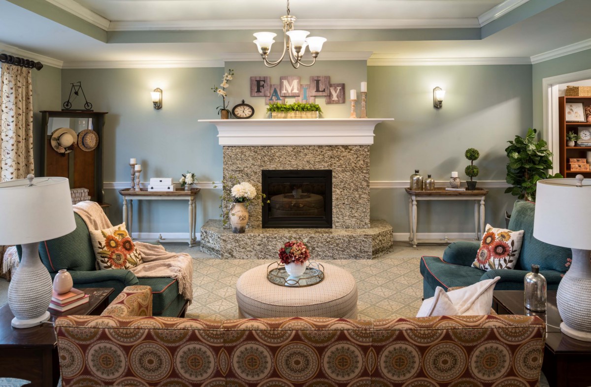 A cozy and elegantly decorated living room featuring a central fireplace, comfortable seating, and ambient lighting.