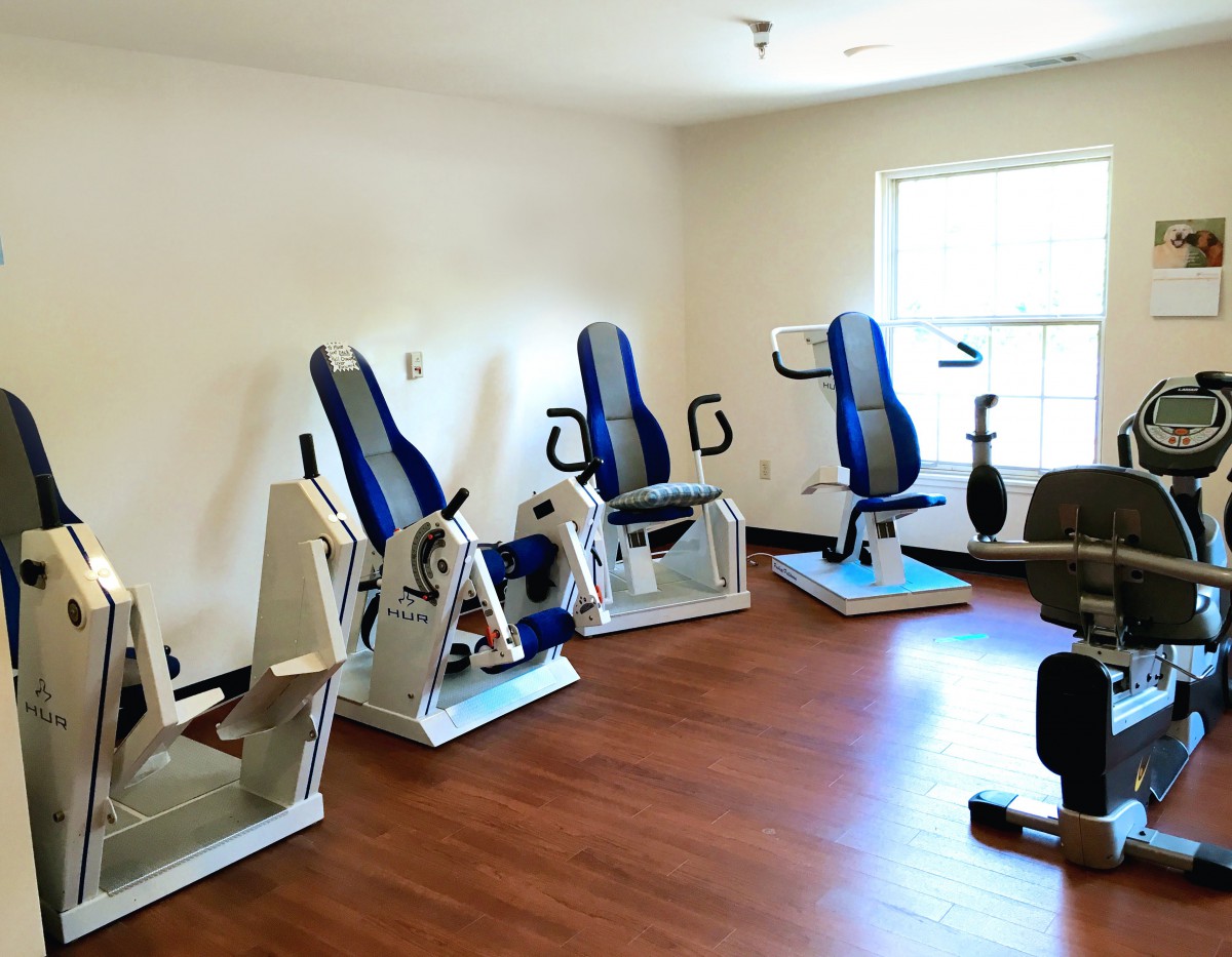 A well-lit gym room featuring various exercise machines for working out.