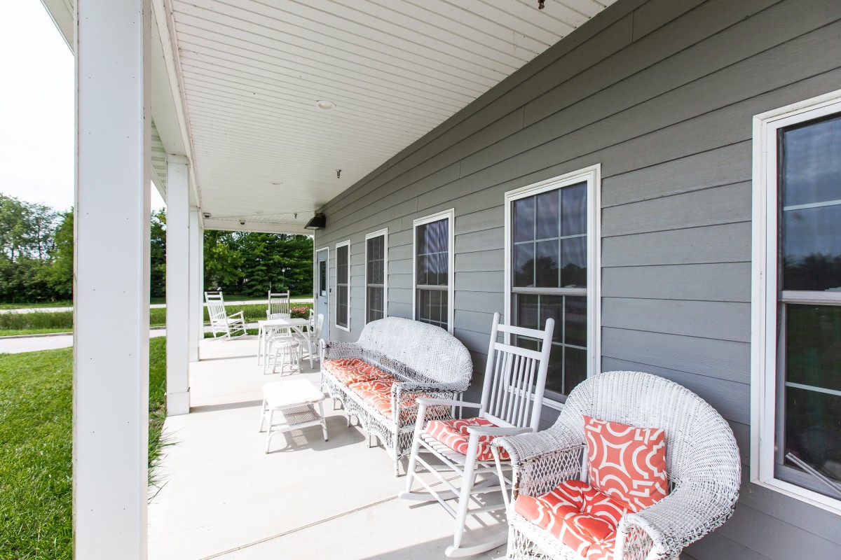 A welcoming porch with rocking chairs and colorful pillows, perfect for relaxation.