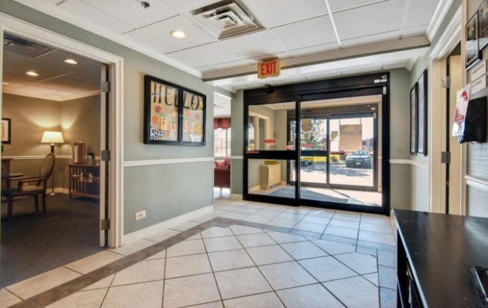 A well-lit lobby with tiled flooring and glass entrance doors.