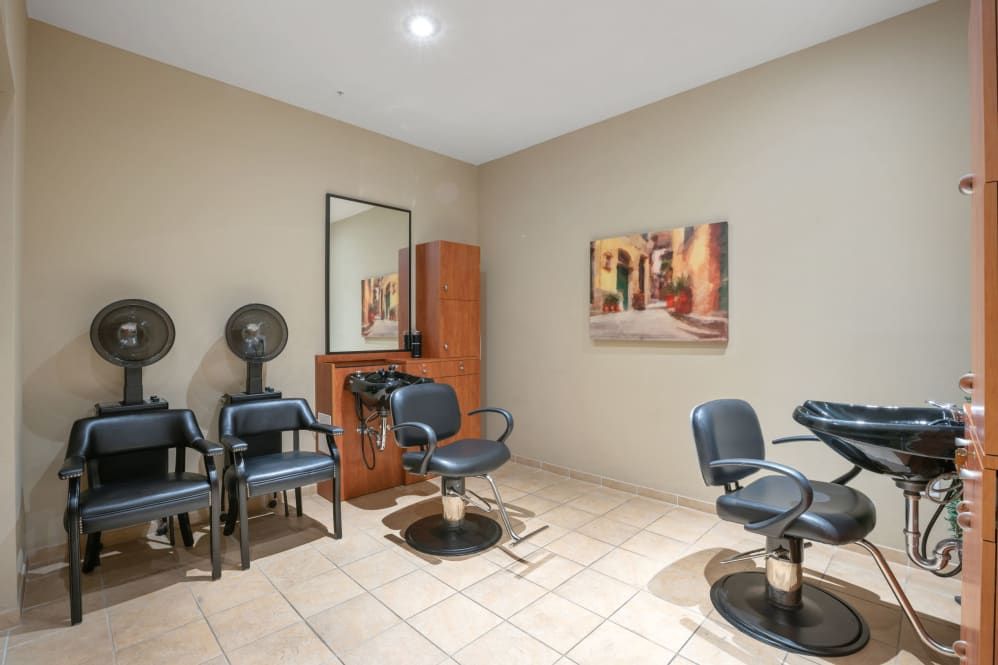 Interior of a hair salon with chairs, mirrors, and hair dryers.