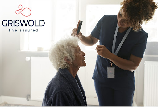 A caregiver gently styling the hair of an elderly woman, providing compassionate personal care.