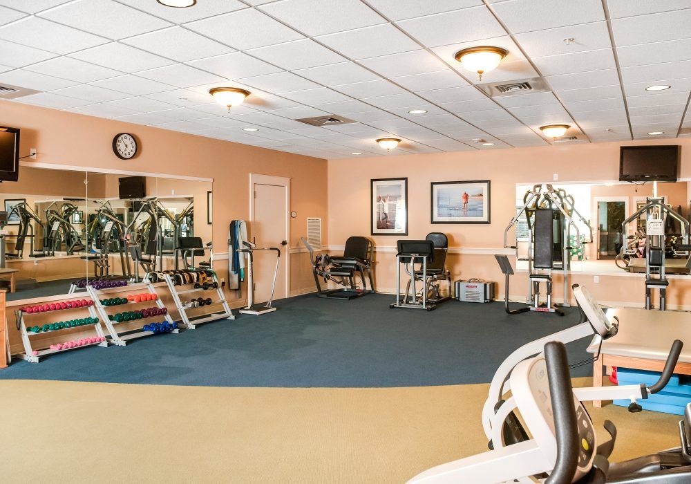 A spacious gym with various exercise equipment and a clean interior.