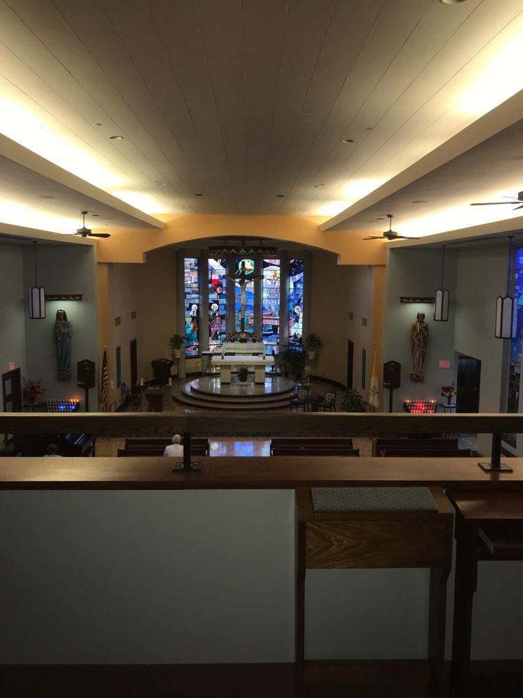 Interior of a church featuring stained glass windows and an altar.