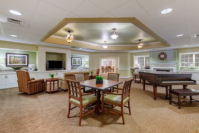 A cozy and well-furnished living area featuring a dining table, comfortable seating, and a television.
