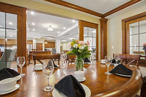 An elegant dining room setup featuring a beautifully arranged table with flowers, perfect for a special occasion.