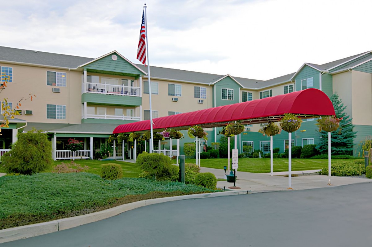 A hotel entrance with a red canopy and an American flag flying on a flagpole.