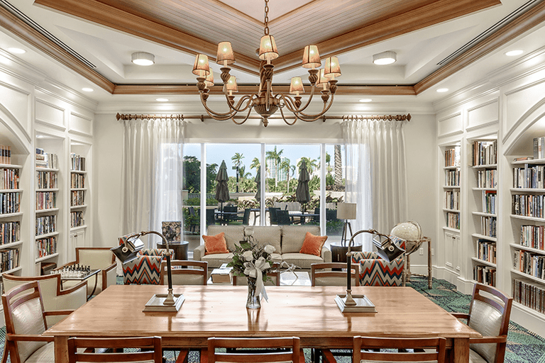 A luxurious living and dining area with elegant furnishings and a grand chandelier.