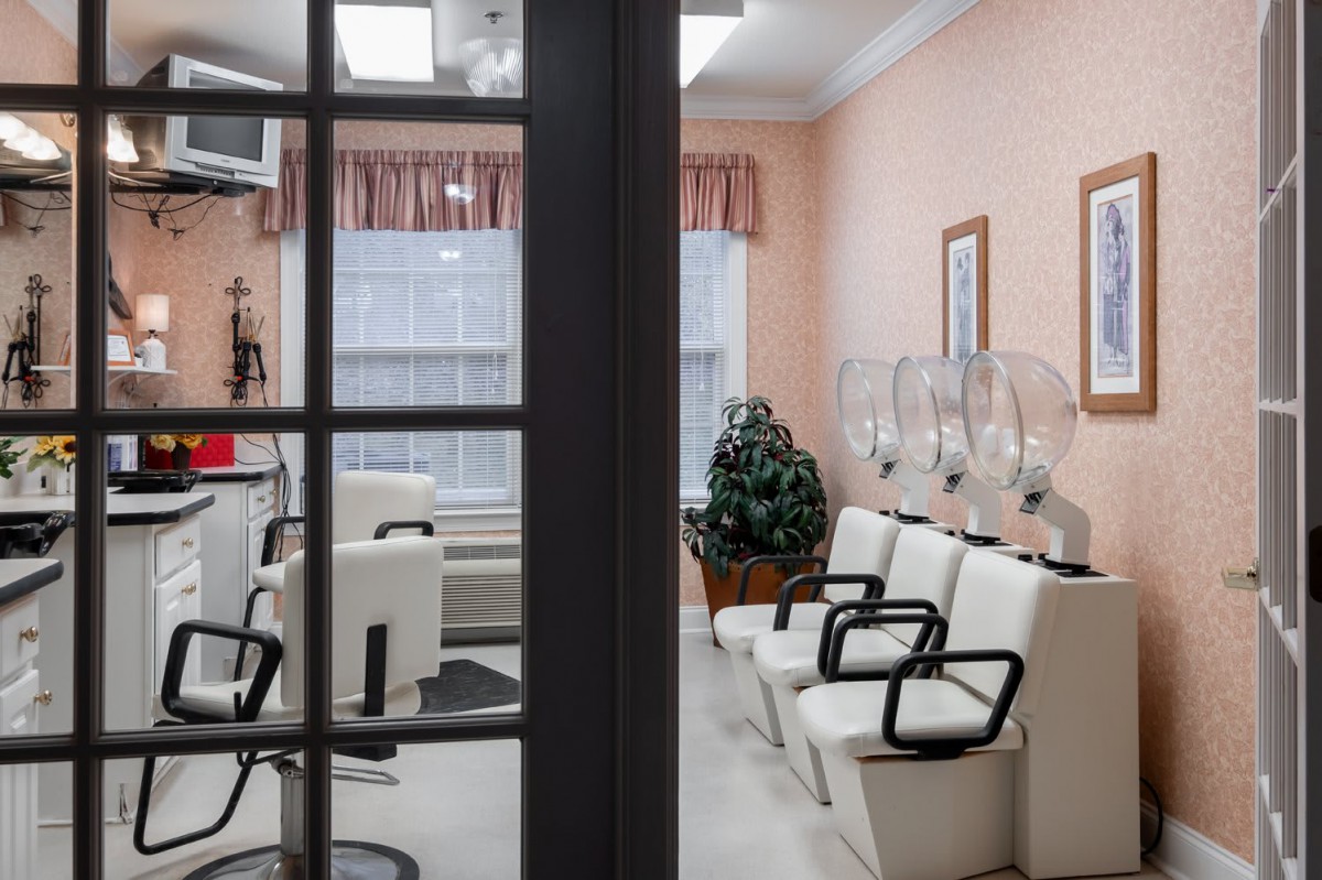 A glimpse into a cozy hair salon waiting area with chairs and hair dryers.