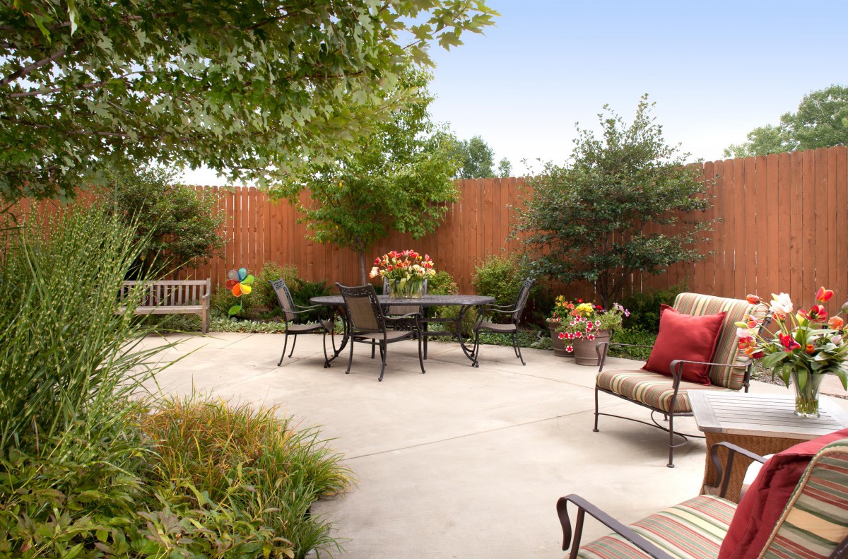 A cozy outdoor patio with comfortable seating and lush garden surroundings.