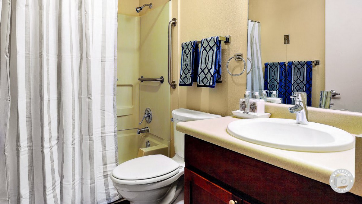 A small bathroom with a shower, toilet, and sink.