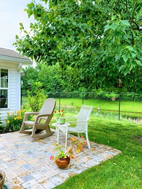 A peaceful patio setting with chairs overlooking a lush garden.
