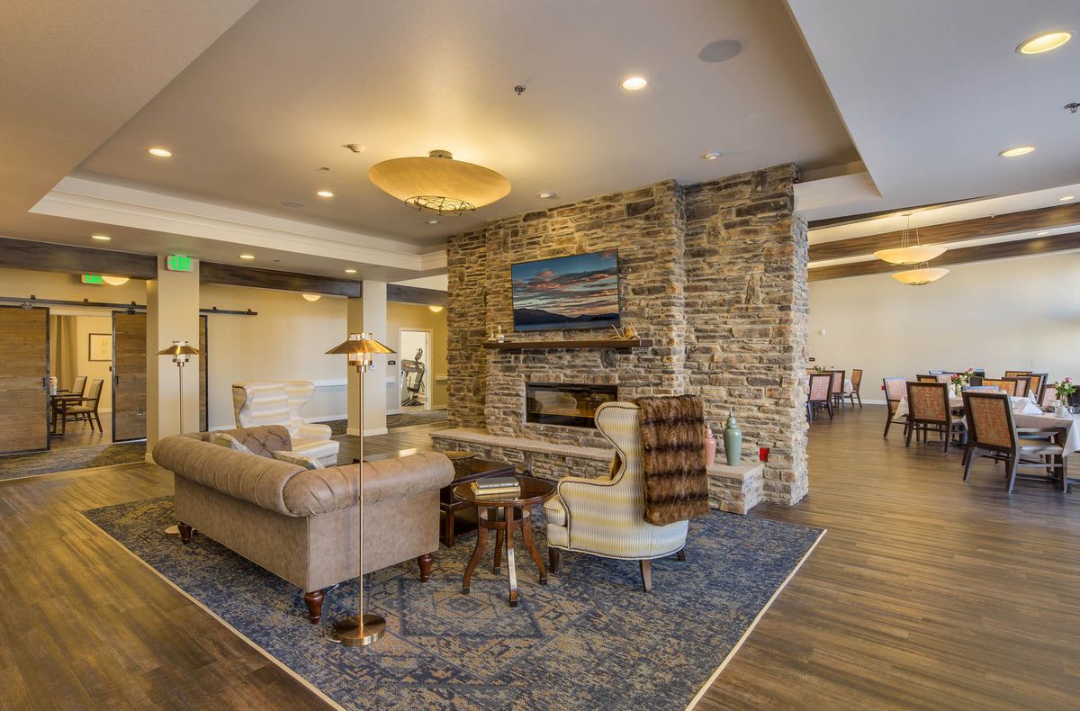A cozy lobby area featuring a stone fireplace, comfortable seating, and elegant decor.