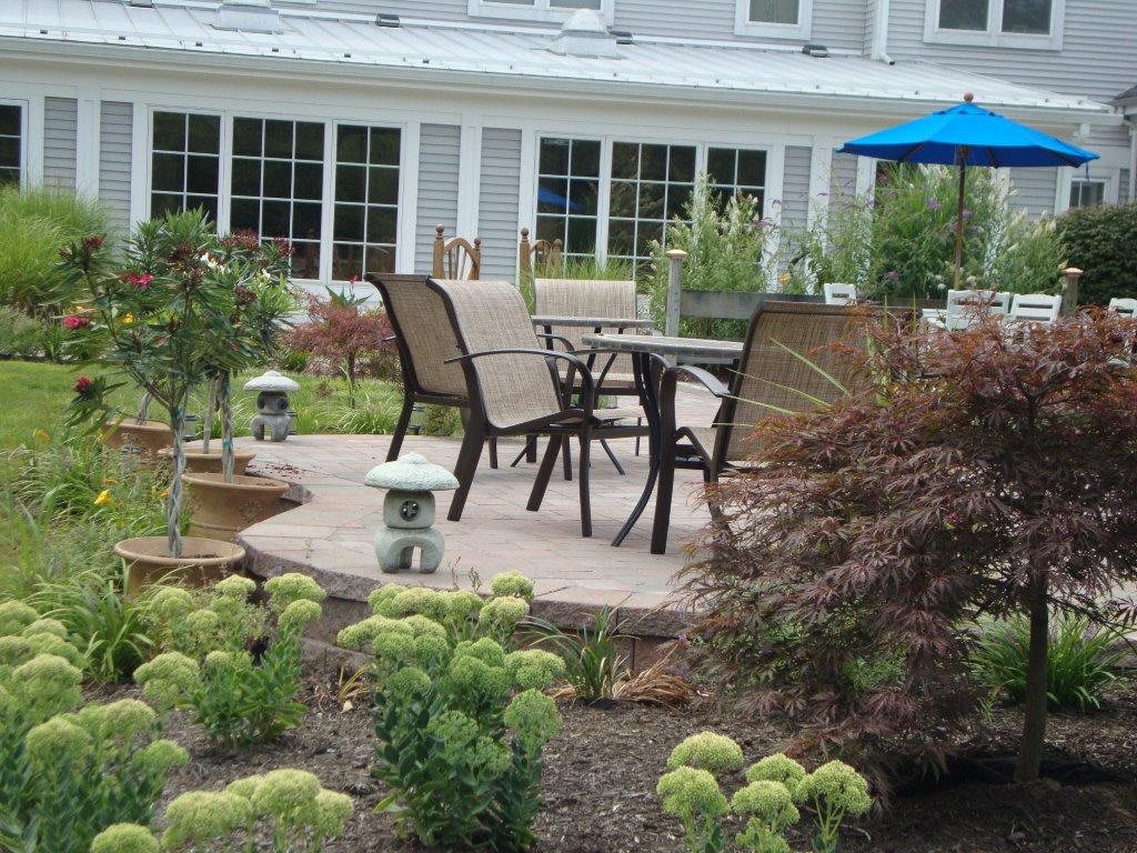 A beautifully landscaped garden with a patio and outdoor seating area.