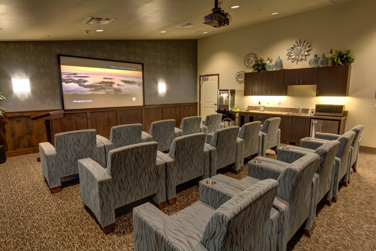 A cozy home theater setup with comfortable seating and a large screen for viewing.