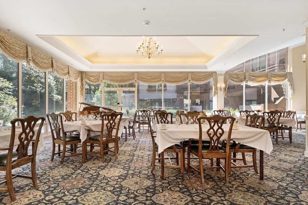 Elegant dining room with multiple tables and a chandelier.