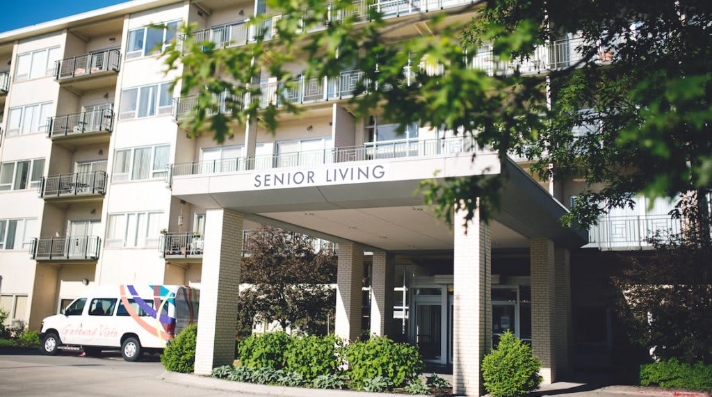 The entrance to a senior living facility with a welcoming architectural design.