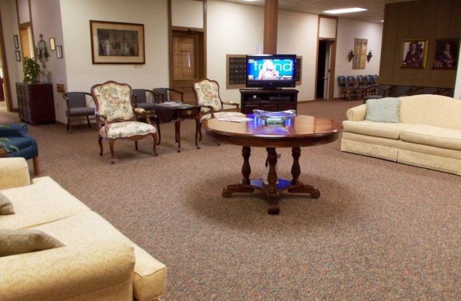 A cozy waiting room with various seating options and a television.