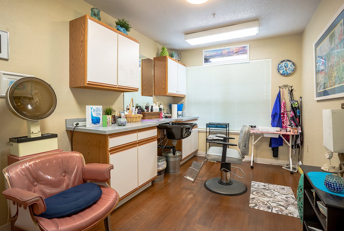 A cozy hair salon interior with chairs, a sink, and various salon equipment.