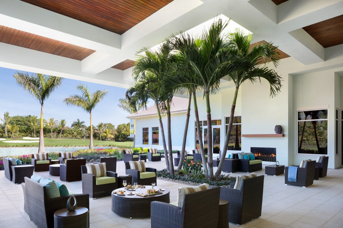 A modern outdoor patio featuring comfortable seating and palm trees, ideal for relaxation.