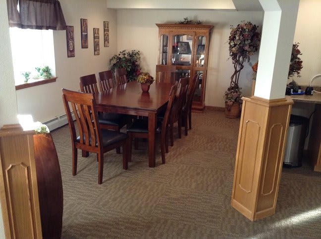 A traditional dining room with a wooden table, chairs, and a display cabinet.