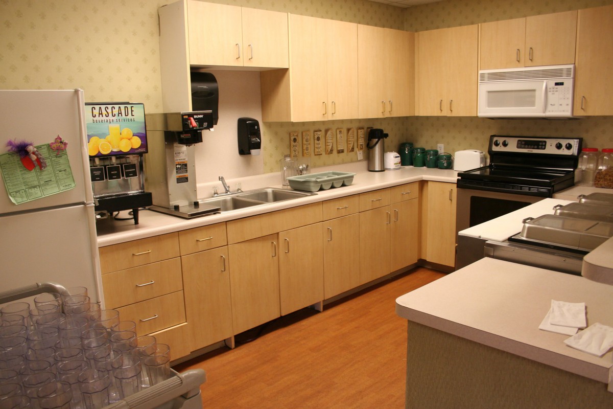 A modern kitchen with wooden cabinets and appliances such as a microwave and coffee maker.