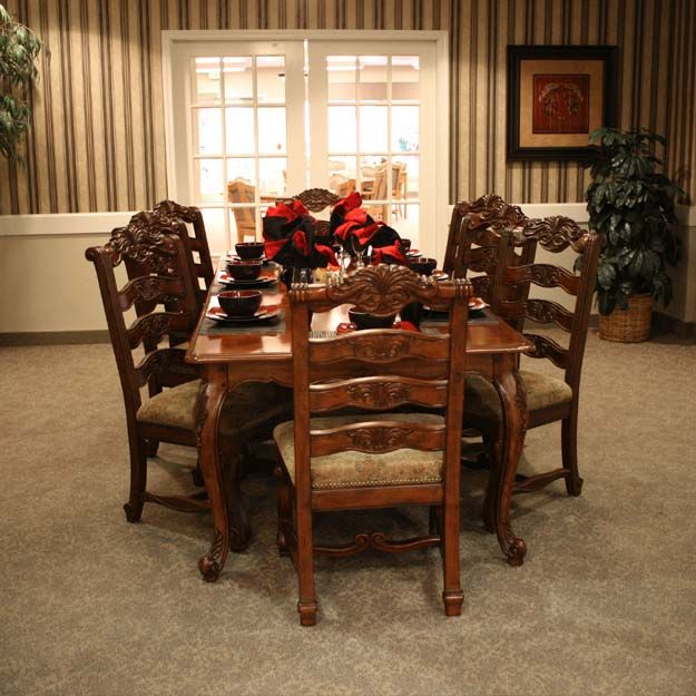 A well-decorated dining room with an elegant wooden table and matching chairs, set in a cozy interior with warm lighting.