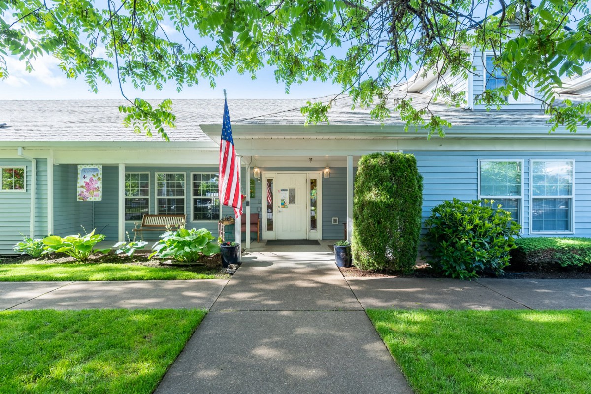 A charming house with a well-maintained front yard and an American flag displayed by the entrance.