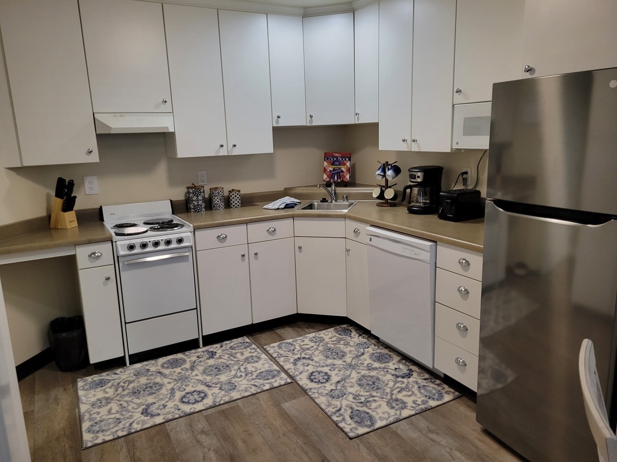 A clean, modern kitchen with white cabinets and essential appliances.