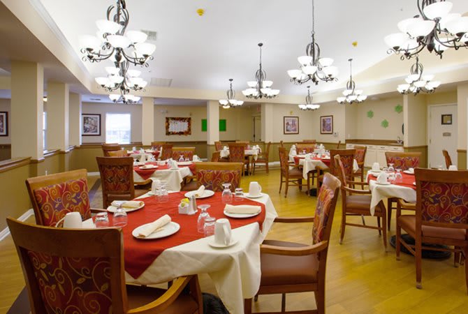 An elegant dining room featuring well-set tables and chandeliers.