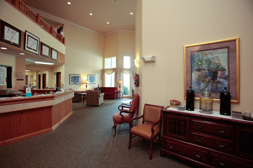 A spacious lobby featuring a reception area with comfortable seating and decorative artwork.