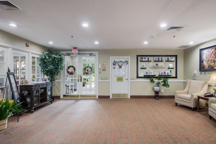 A well-lit lobby with decorative elements, including plants and seating arrangements.