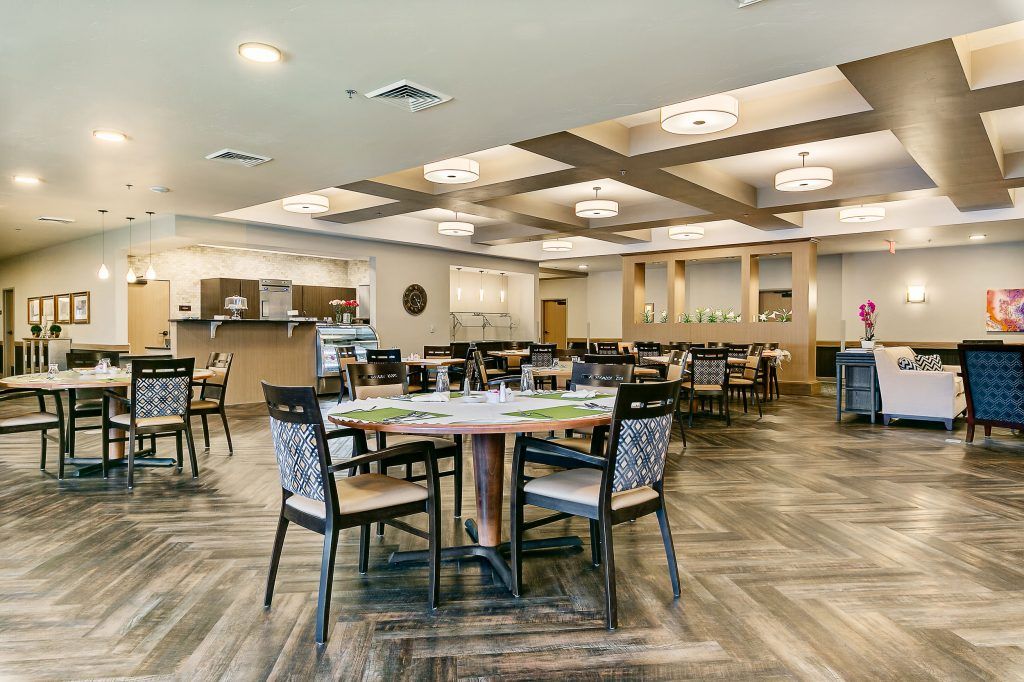 A modern and spacious restaurant dining area with elegant furnishings and lighting.