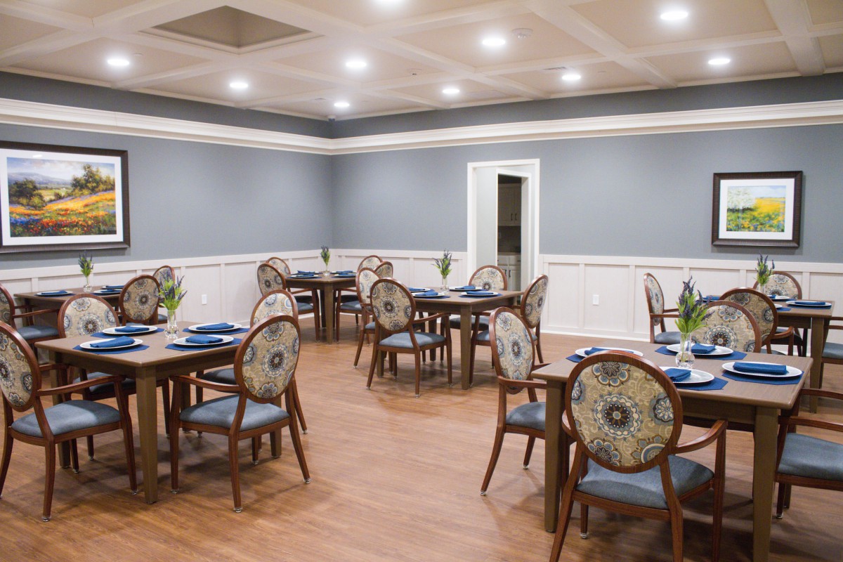 A well-lit dining room with elegantly arranged tables and chairs.