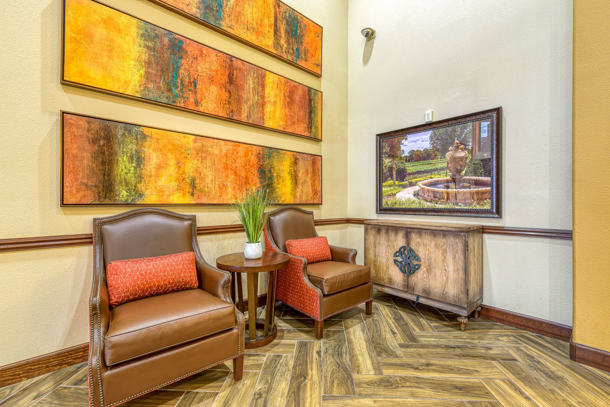 A cozy lobby area featuring comfortable chairs, vibrant artwork, and warm decor.