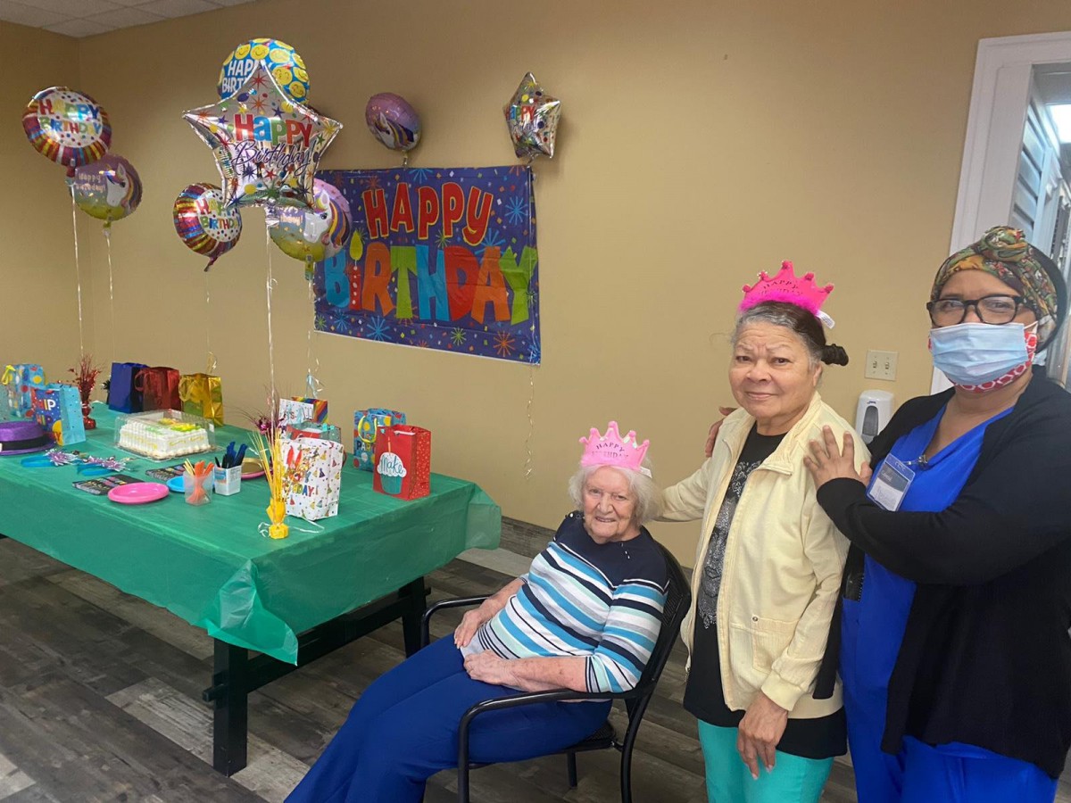 A joyful birthday celebration with colorful balloons, gifts, and happy attendees wearing festive hats.