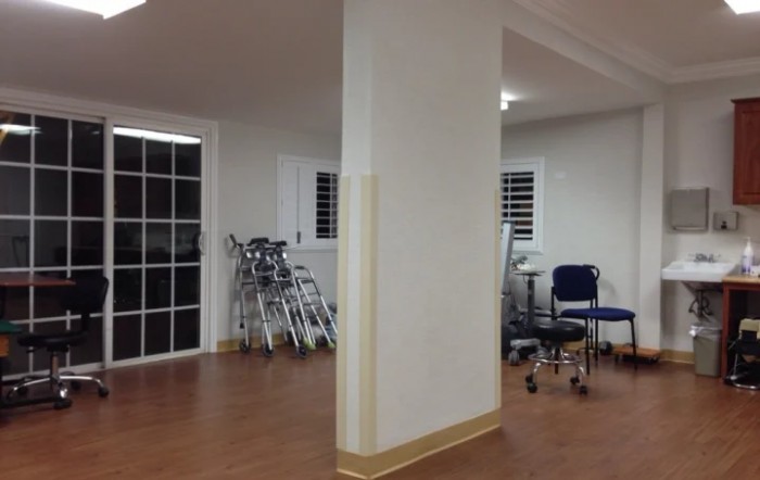 A hospital corridor with wheelchairs lined against the wall.