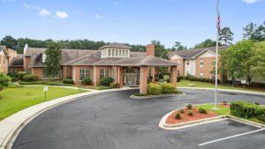 A residential building with a circular driveway and well-maintained landscaping.