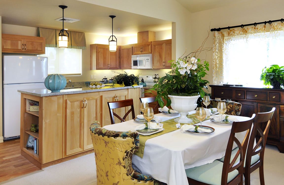 A cozy open-concept kitchen and dining area with a beautifully set table and wooden cabinets.
