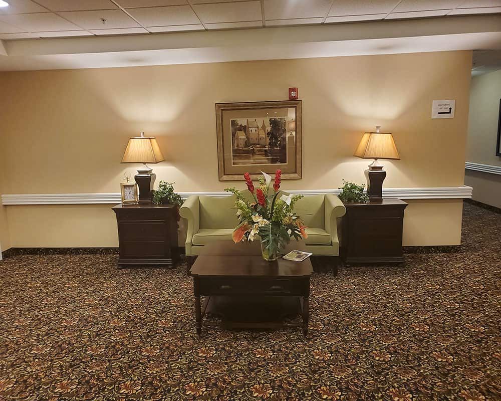 A cozy lobby area with a green sofa, decorative table, and ambient lighting.