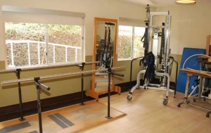 A well-equipped indoor gym with exercise machines and a large mirror.