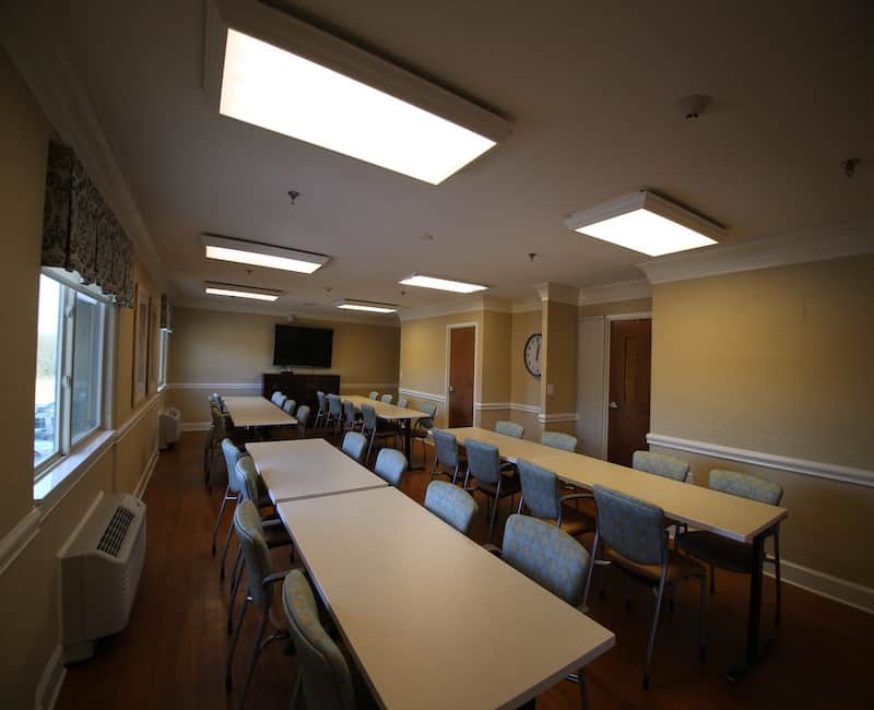 A well-lit conference room with tables and chairs arranged for a meeting.