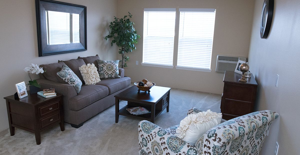 A cozy living room with a sofa, coffee table, and decorative cushions.