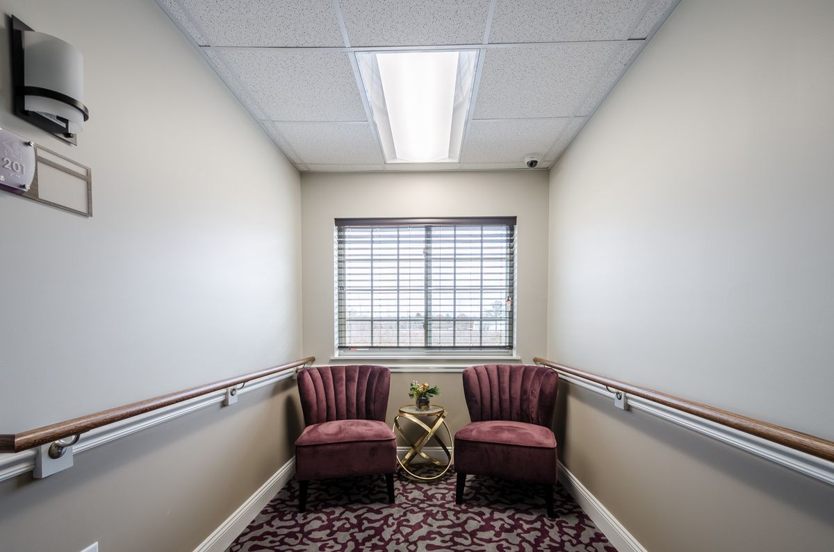 A small corridor with two chairs facing a window, featuring decorative accents.