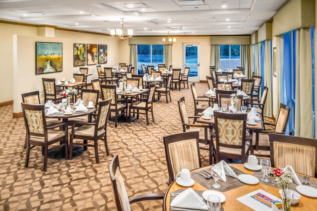 An elegant dining room set with tables and chairs, ready for guests.