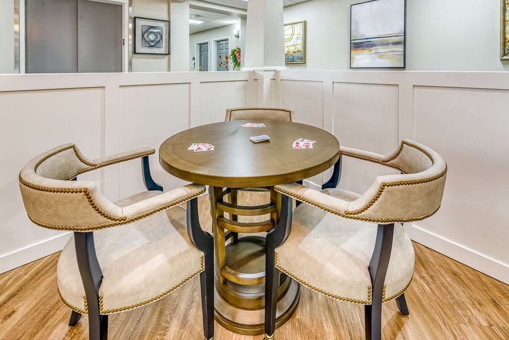 A modern seating area with a round table and four upholstered chairs in a stylish room.