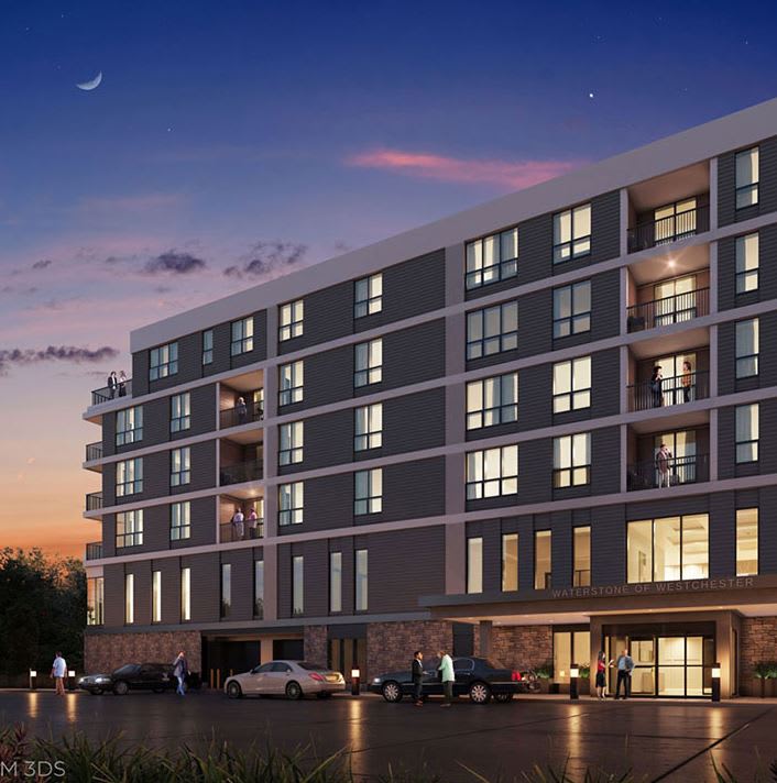 A modern residential building during sunset with illuminated windows.